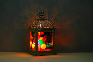 Wall Mural - Decorative Arabic lantern on table against dark background. Space for text