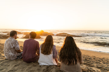 Sticker - Group of friends sitting on a beach, gazing at the sea