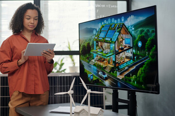 Aufkleber - Screen with new architectural project and two models of windmill standing on desk against young female employee making presentation