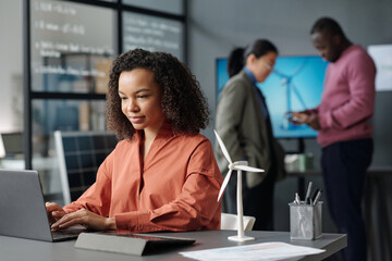 Aufkleber - Young serious businesswoman touching keys of laptop keyboard and looking at screen while searching for information by workplace