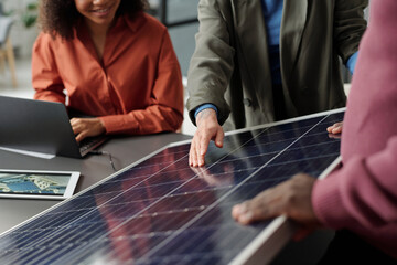 Aufkleber - Cropped shot of young businesswoman in formalwear pointing at solar panel model while making presentation to colleagues by workplace
