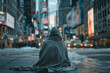 Samotny mężczyzna w kapturze siedzący zimą w dużym mieście