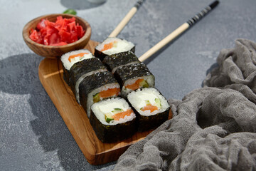 Poster - Maki sushi rolls with salmon, cucumber, and cream cheese, complemented by ginger and wasabi, ready for delivery