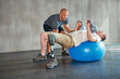 © peopleimages.com - Physiotherapy, patient or man with disability and kettlebells for exercise at gym for recovery, strength and healthcare rehabilitation. Physiotherapist, help or support and consultation for amputee