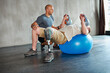 © peopleimages.com - Physiotherapy, exercise and patient with kettllebell or ball at gym for man recovery, strength and healthcare rehabilitation. Physiotherapist, help and support or consultation and people workout