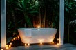 sleek bathroom with a freestanding tub in a tropical bungalow, a person inside surrounded by candles