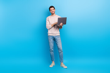 Fototapete - Full size photo of nice young man use laptop chatting wear beige sweatshirt isolated on blue color background