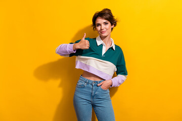 Wall Mural - Photo of pretty nice young girl shot thumb up approve empty space wear shirt isolated on yellow color background