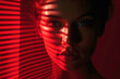 Portrait of attractive woman in red light. Headshot of young woman looking at camera. Mood portrait of girl. Dramatic female photo