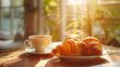 A cup of hot coffee and fresh croissants. French breakfast on a sunny day at a cafe table. Fresh pastries.