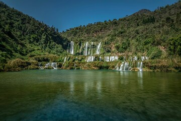 Wall Mural - View of the Jiulong waterfall streaming down to a lake