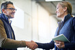 © peopleimages.com - Handshake, welcome and business people for collaboration, partnership or agreement on deal. Lens flare, tablet and shaking hands for export support, b2b meeting or distribution in shipping factory