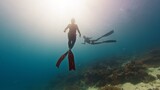 Fototapeta  - Two male freedivers swim underwater and explores vivid and healthy coral reef in Komodo National Park in Indonesia