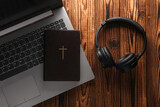 Fototapeta Mapy - Bible book with laptop and headphones on a wooden table. Online Bible study