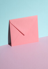 Wall Mural - Pink square paper envelope on pastel background