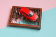 Selling or buying a car, maintenance costs concept. Toy car and abacus on a blue-pink background