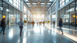 Motion blur of people walking rapidly in corporate building hallway