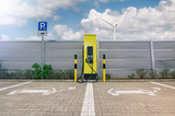 Fototapeta Perspektywa 3d - Ladestation für Elektroautos mit Windräderm im Hintergrund die Ökostrom erzeugen