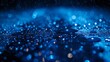   A tight shot of a raindrop atop a surface against a backdrop of blue lights, accompanied by additional raindrops on said surface