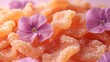   A tight shot of a mound of sugared doughnuts adorned with floral garnishes