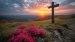   A hilltop cross with pink flowers in the foreground and sunset in the background