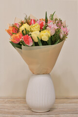 Wall Mural - A bouquet of flowers in ceramic vase stands on a table in the room