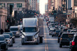 Semi truck leads a busy urban road, symbolizing logistics and transportation in the city