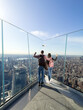 © David Prado/Stocksy - Man and Woman Overlooking Manhattan from Transparent Balcony