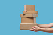 © Yaroslav Danylchenko/Stocksy - Close up of female hands holding stack of cardboard boxes