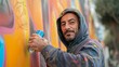 Man in Hoodie Spray Painting Wall