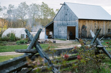 Barn at farm with a bon fire burning in fall