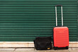 © SIYUN YUH/Stocksy - Red baggage with briefcase in front of green iron gate in Venice