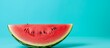A slice of Citrullus lanatus watermelon, a juicy fruit and natural food, is placed on a blue table. The closeup view highlights the plantbased liquid ingredient of this refreshing melon