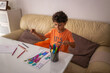 © Lupe Rodríguez/Stocksy - little boy coloring a nice drawing at home