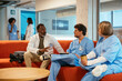 © BONNINSTUDIO/Stocksy - Healthcare workers taking a break sitting on sofa