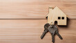 Buying a house with key on a grained wooden board