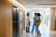 © BONNINSTUDIO/Stocksy - Healthcare workers waiting elevator at hospital