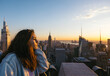© Pedro Merino/Stocksy - Woman on a skyscraper in New York at sunset