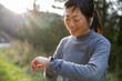 © Jovo Jovanovic/Stocksy - Smiling athlete analysing jogging track on smartwatch on sunny day
