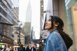 © Pedro Merino/Stocksy - A tourist in New York, looking up in awe at the tall skyscrapers