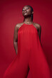 © Elena Kharichkina/Stocksy - Fashionable black model posing on red background
