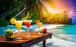 Summer cocktails on wooden table in front of tropical beach with palm trees