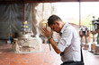 © Alvaro Lavin/Stocksy - Man praying at temple.