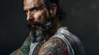 A tattooed man with a full beard and extensive body ink stares seriously at the camera on a dark background