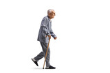 Fototapeta Panele - Full length profile shot of a en elderly man in pajamas walking with a cane