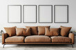 A spacious Scandinavian living room with a caramel brown sofa set against a soft white wall. Four blank empty mock-up poster frames in a sleek black finish