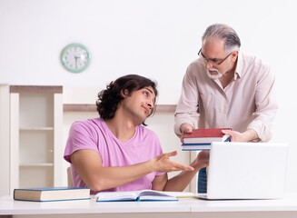 Wall Mural - Old father helping his son in exam preparation