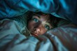 A person lying in bed with eyes wide open staring at a ceiling in the dark