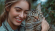 Close-up of a happy woman affectionately embracing her striped tabby cat in a natural outdoor setting