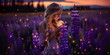 A blonde girl holding a moon in her hands and standing among a blooming purple lupine field with lights and fireflies. A magical night portrait.